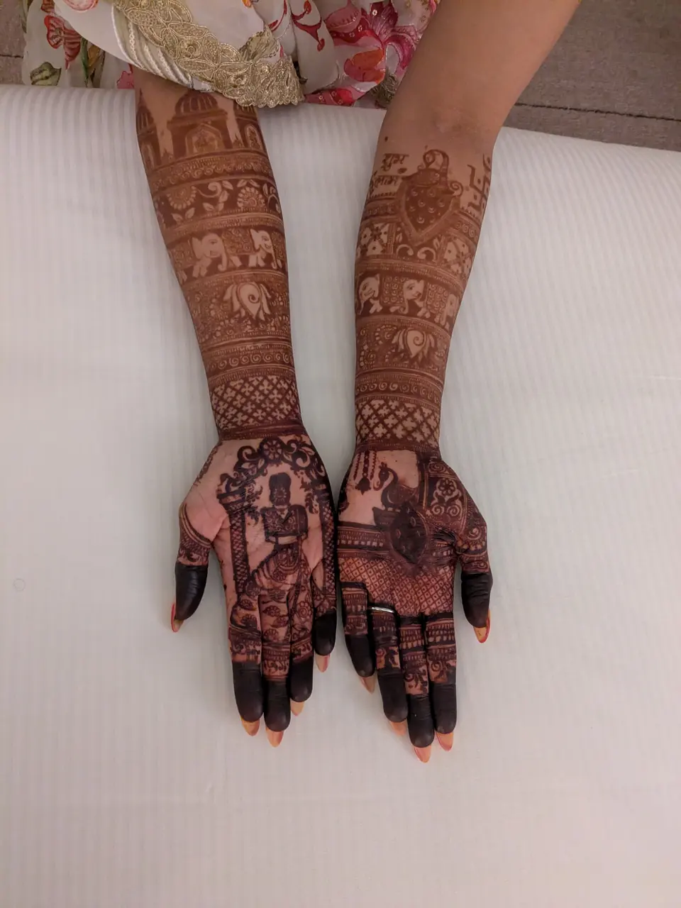 Deep maroon henna stain on a bride's hands and forearms